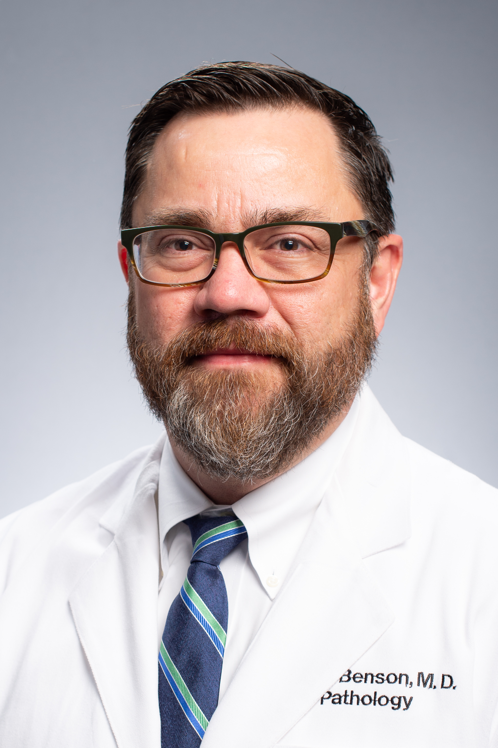 Headshot of Dr. Paul Benson, MD (Associate Professor, Anatomic Pathology) in white medical coat, 2020.