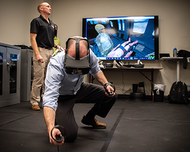 An attendee tries the VR headset in the SOCMID office and is transported to the back of an aircraft with a severely injured patient.