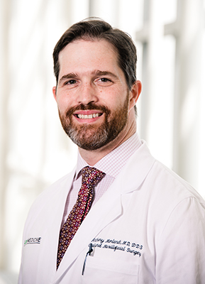Environmental head shot of Dr. Anthony Morlandt, MD (Associate Professor, Oral and Maxillofacial Surgery) in white medical coat, 2019.