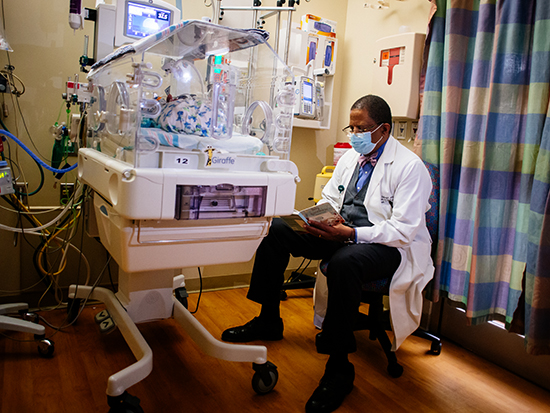 Selwyn Vickers, M.D., dean of the UAB Marnix E. Heersink School of Medicine, reading book to NICU baby.
