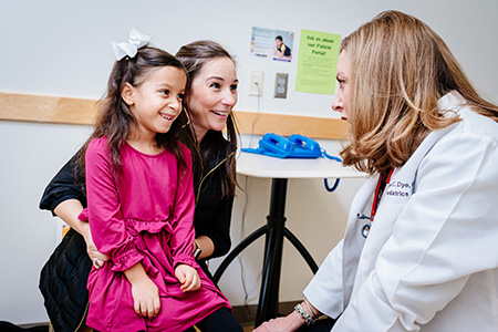 Dr. Candice Dye, MD (Associate Professor, General Pediatrics) is talking to a female pediatric patient and her mother at the UAB Pediatric Primary Care Clinic, 2019.