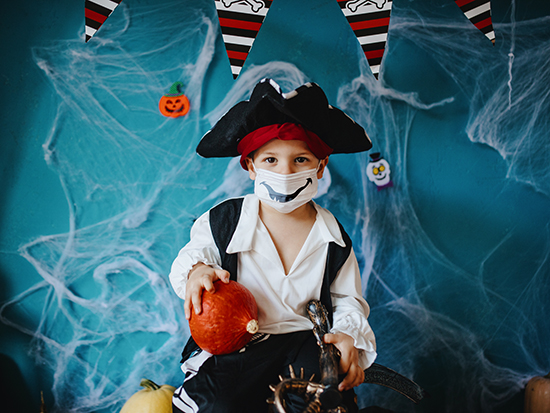 Little boy wearing Halloween costume and protective face mask during Covid-19 pandemic