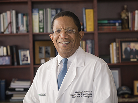 Environmental head shot of Dr. Selwyn Vickers, MD (Senior VP, Medicine; Dean, Medicine) in white medical coat in his office, 2018.