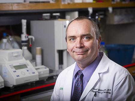 Environmental close-up of Dr. David Geldmacher, MD (Professor, Neurology) in white medical coat in laboratory, 2017.