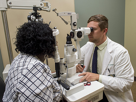 UAB Eye Care (Western Health Center). Unidentified opthalmologist giving eye exam to female patient, 2015.