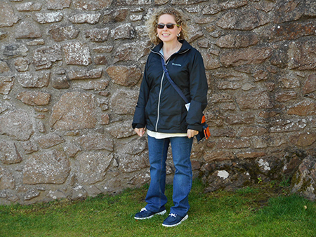 Image of Karen Hay standing against stone wall. 