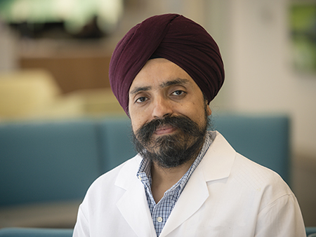 Environmental head shot of Dr. Jasvinder Singh, MD (Professor, Immunology/Rheumatology) in white medical coat, 2018.