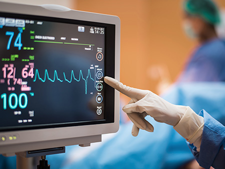 Health care worker pointing at EKG screen