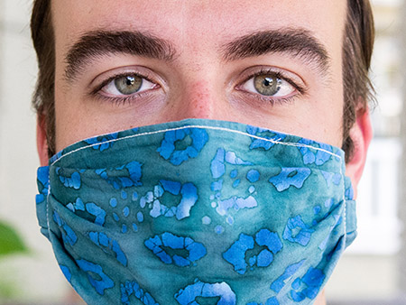 Close-up of Jordan Lingo (Graduate Student, Microbiology) wearing a homemade fabric mask while standing outdoors during the COVID-19 (Coronavirus Disease) pandemic, April 2020.