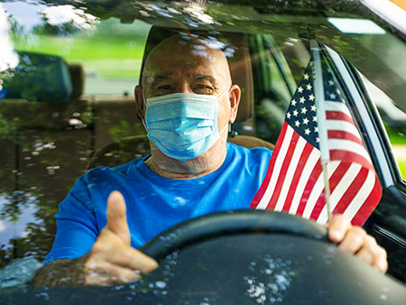 Senior man with american flag and protective mask