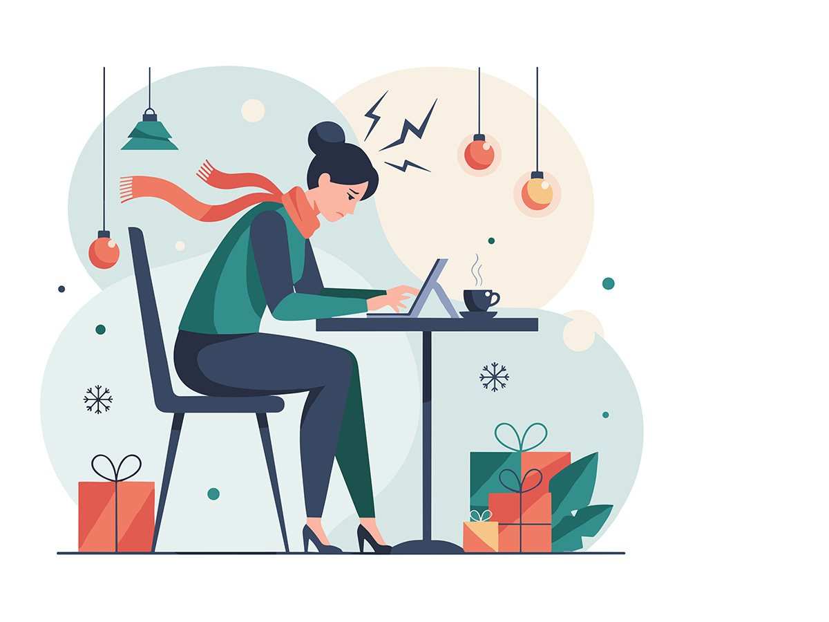 Woman with headache working on laptop surrounded by holiday gifts illustrating seasonal stress and burnout