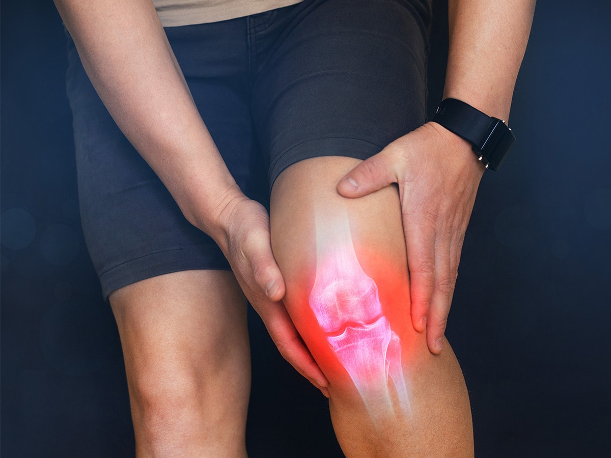 Man holding knee due to knee pain.