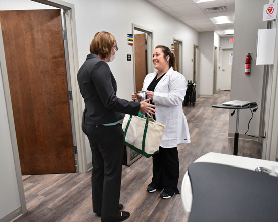 Two people talking outside a medical examination room