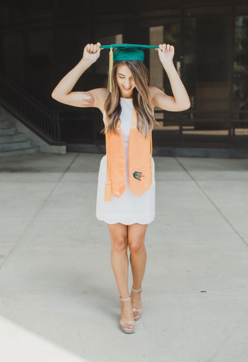 Christy posing with UAB graduation cap and sash.