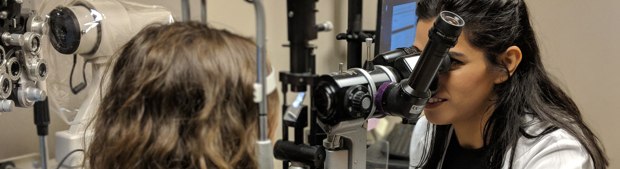 UAB resident conducting eye exam with UAB optometrist overseeing exam.