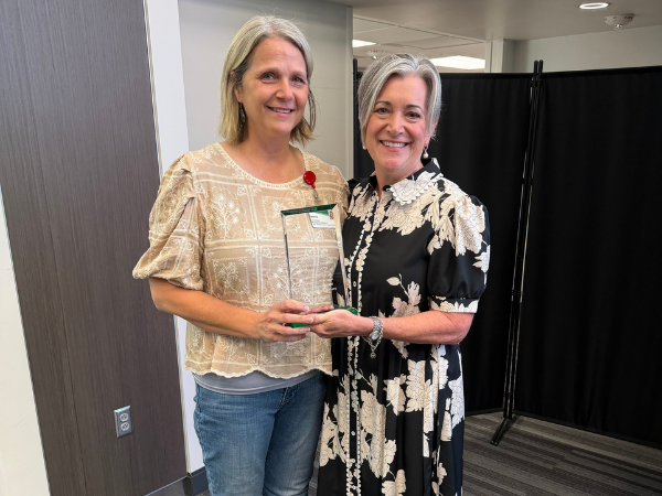 Staff member Mintie Keiser receiving the Dean's Distinguished Service Award from Dean Kelly Nichols.