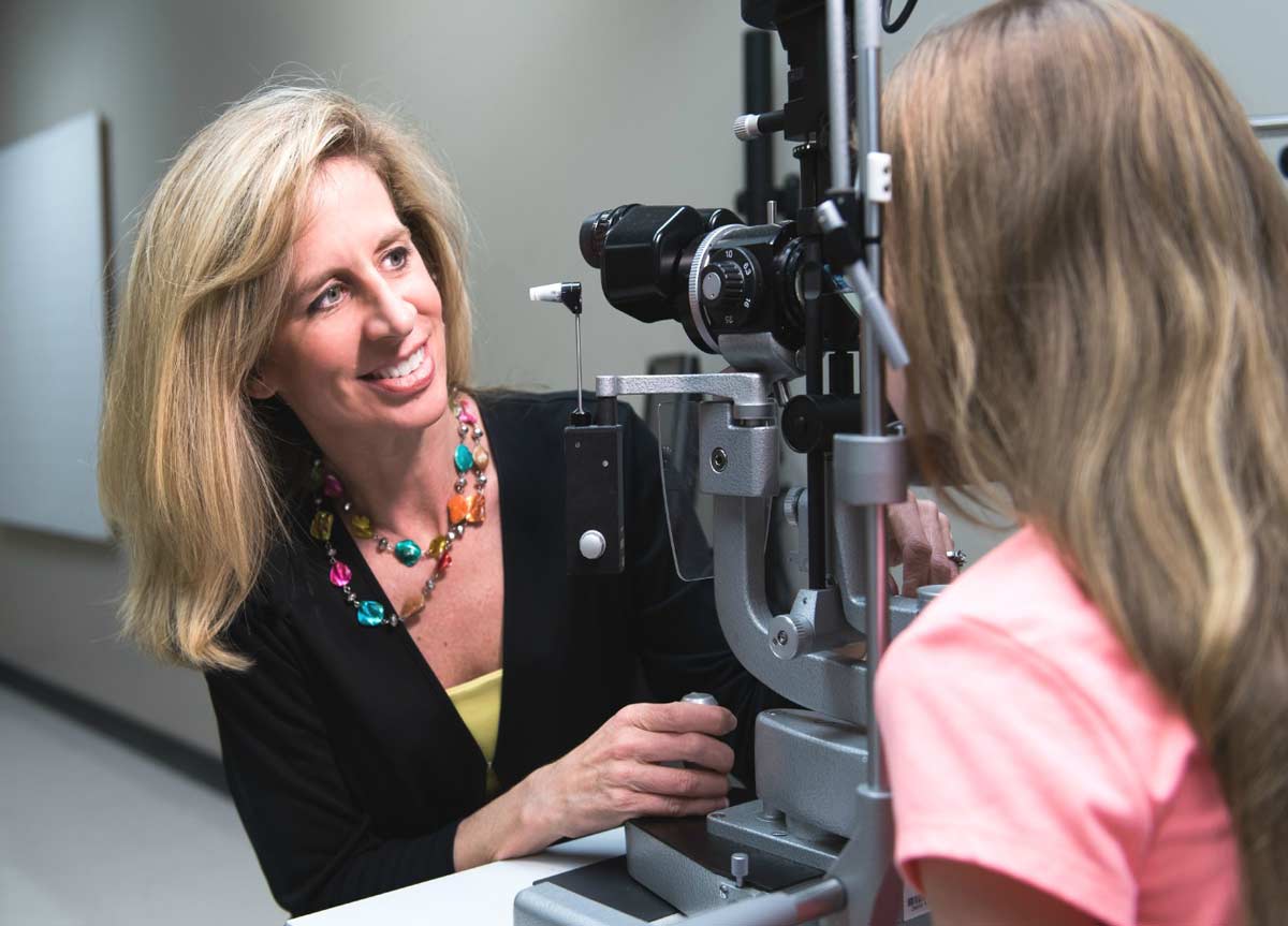 Katherine K. Weise conducting an eye exam on a girl.