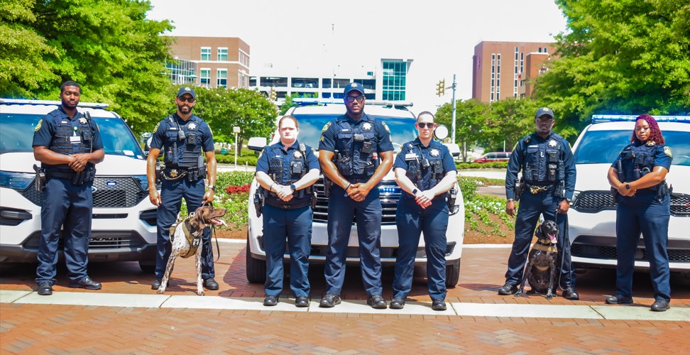 UAB Police Officers along with K-9 unit in front of police vehicles
