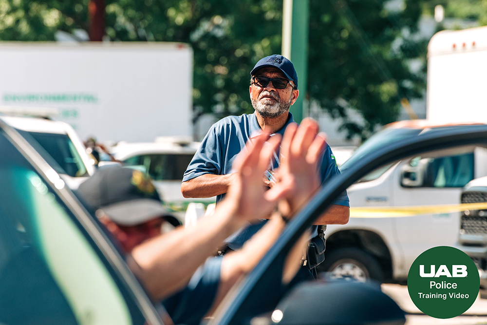 A participant raises his hands while a police officer approaches from behind