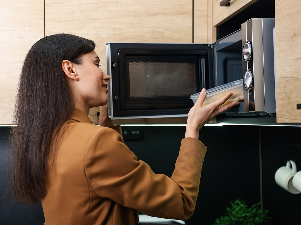 Office worker places food in microwave