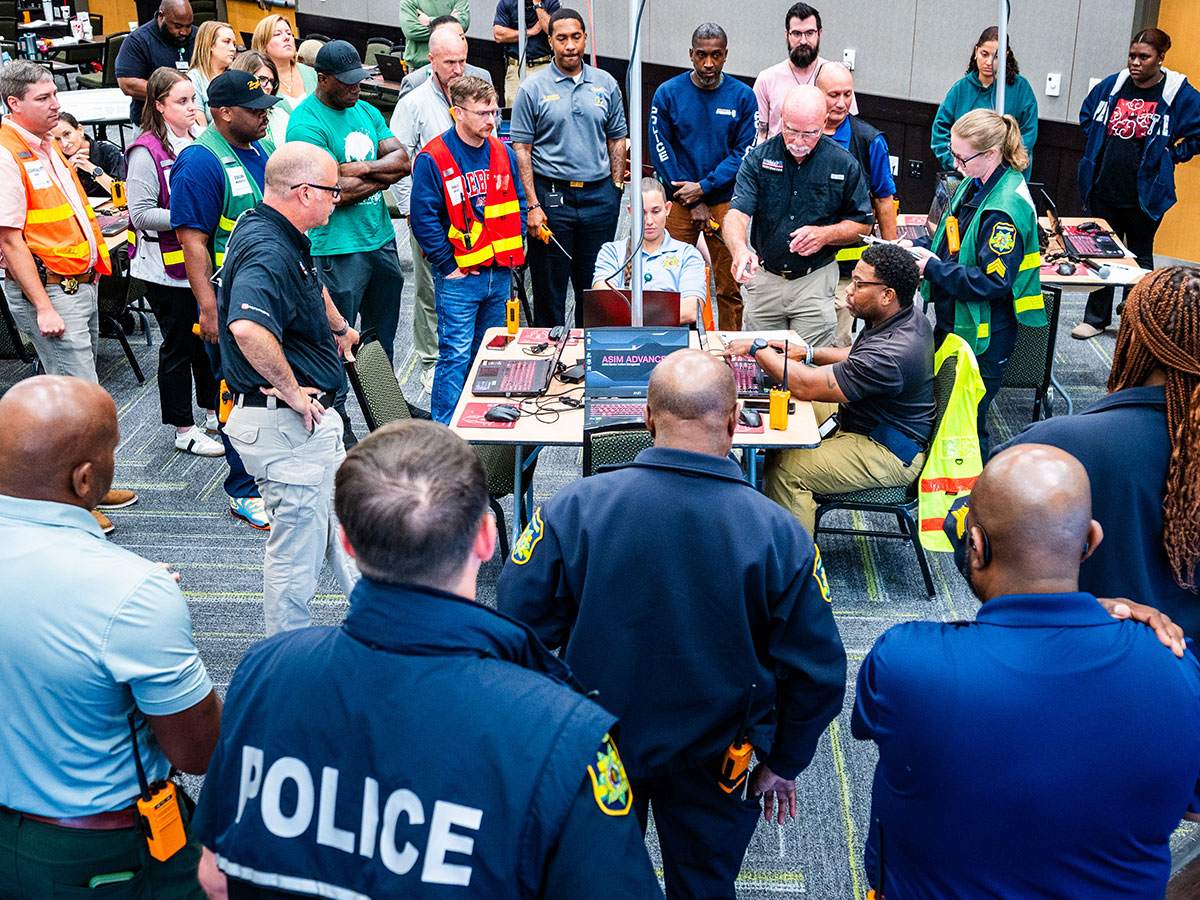 More than two dozen participants from UAB Police and other UAB staff gather around a central table in the Hill Student Center ballrooms during a training exercise