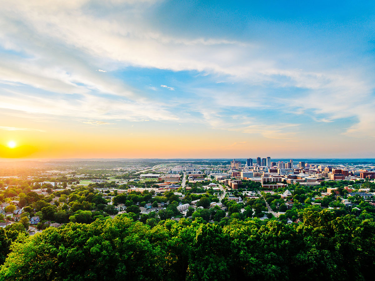 Birmingham and the UAB Campus and Medical Center skyline at dusk under a blue and orange sky