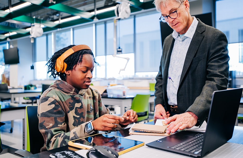 Brianna Savage demonstrates her wheelchair ramp concept to Dr. Tim Wick