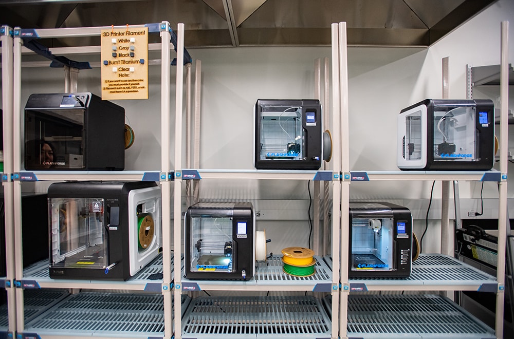 A rack filled with 3D printers in the Design x Prototyping Lab.