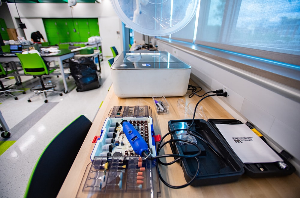 Closeup of a laser cutter and a rotating tool in the Design x Prototyping Lab