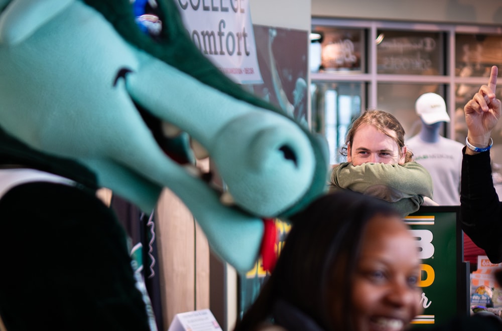 Blaze greets students and employees at the UAB Bookstore while a student looks on