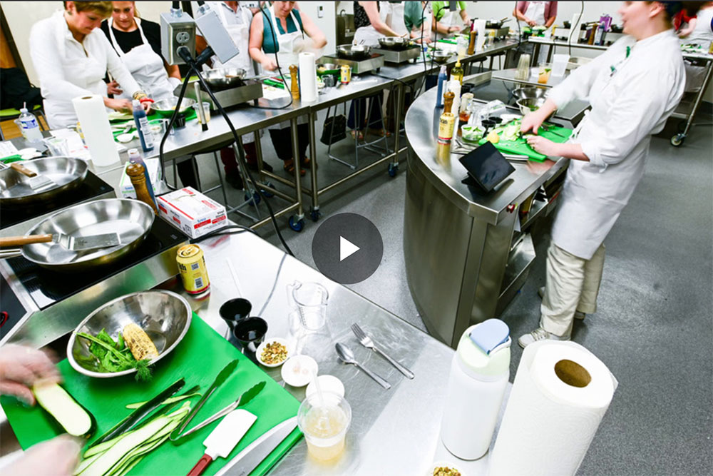 Still frame from time lapse video of cooking class with students around room