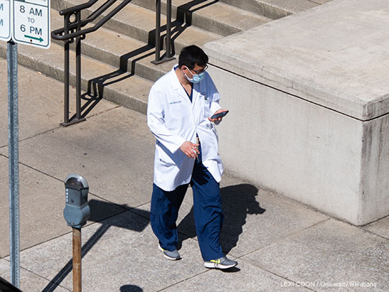 Medical professional walking on UAB's campus with PPE