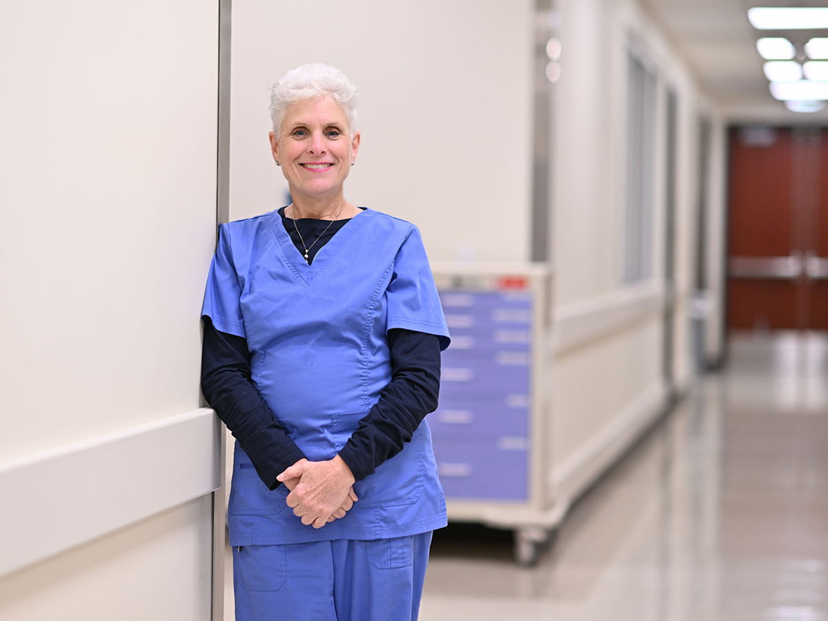 Rita Jablonski, Ph.D., wearing blue scrubs, stands in the simulation suites at the School of Nursing 