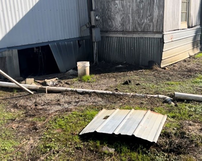 Exposed sewage lines in a house's back yard.