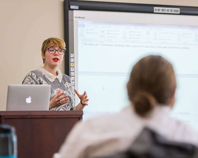 Female faculty member teaching in a classroom.