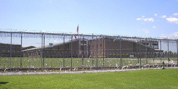 Donaldson prison seen through a high chain link fence with razor wire.