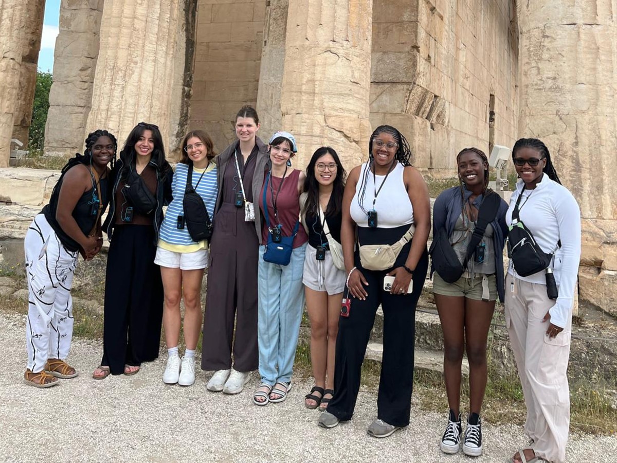 Students posing in front of ruins with columns (possibly the Parthenon)