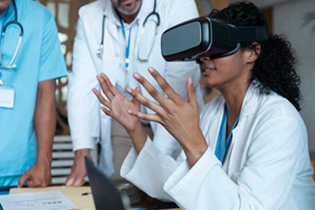A female doctor wearing virtual reality goggles describes the experience to looming colleagues