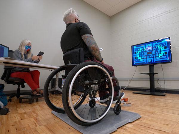 Mendonca sits in a wheelchair while testing the game. 
