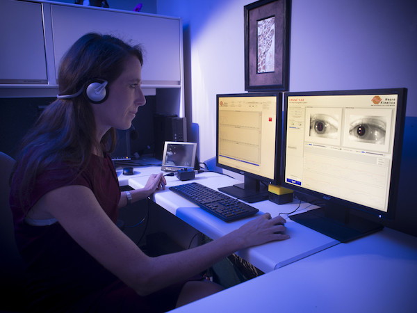 Jennifer Christy sits at monitors in the VOR Lab
