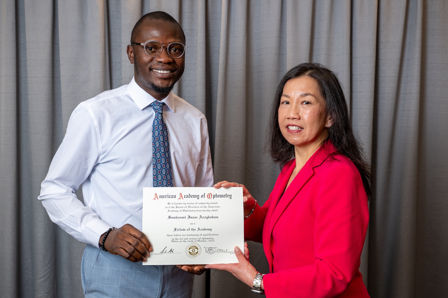 Dr. Arogbokun receives his confirmation as a Fellow of the American Academy of Optometry from Academy Board of Directors member Nancy Wong, OD, PhD, FAAO.