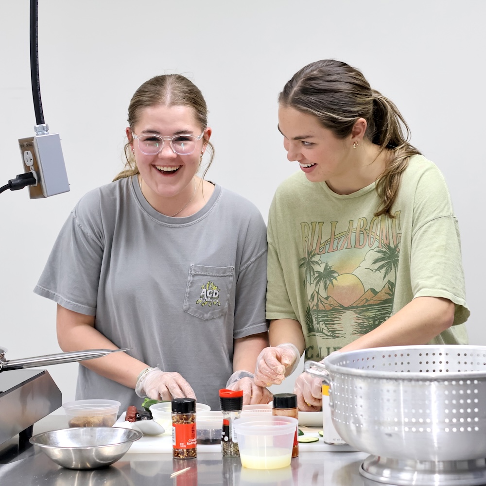 Happy students cooking in Teaching Kitchen.