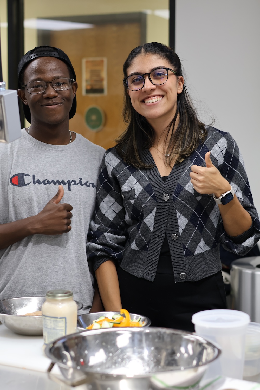 Happy students giving thumbs up.