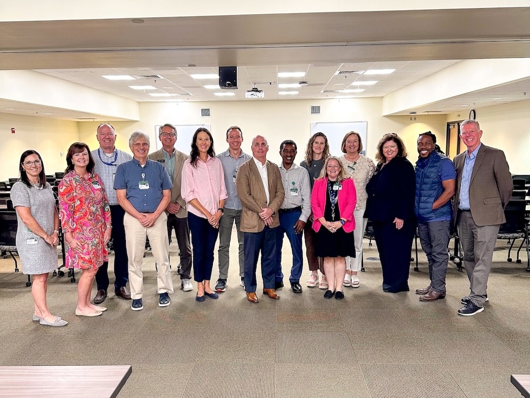 Group photo of faculty with Justin Moore inside a classroom