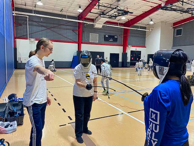 Blind fencing instruction begins! Seen here from left to right are an assistant coach, Pound, and another BVI fencer.