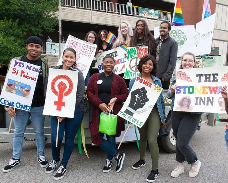 Students holding signs at a diversity gathering. 