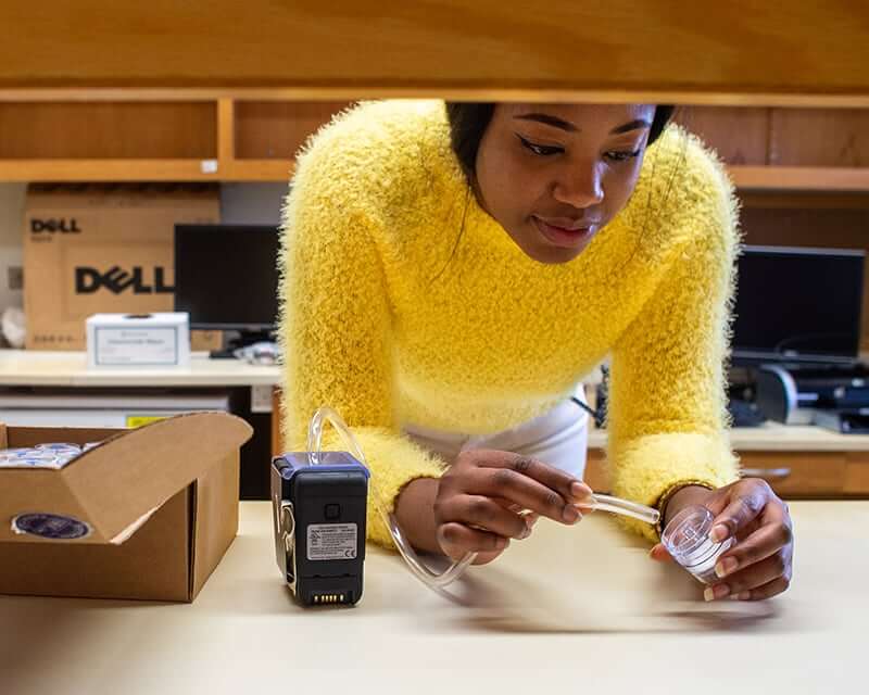 A female black student working in a lab. 