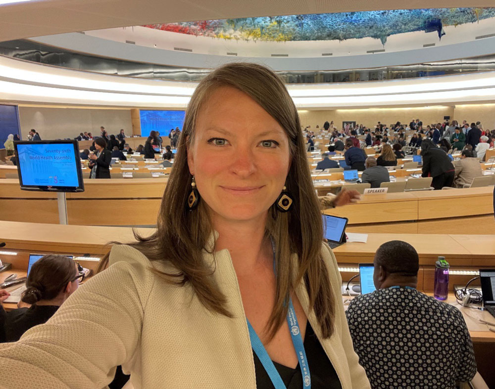 Anastasia Smith in a white jacket takes a selfie at the WHO World Health Assembly.
