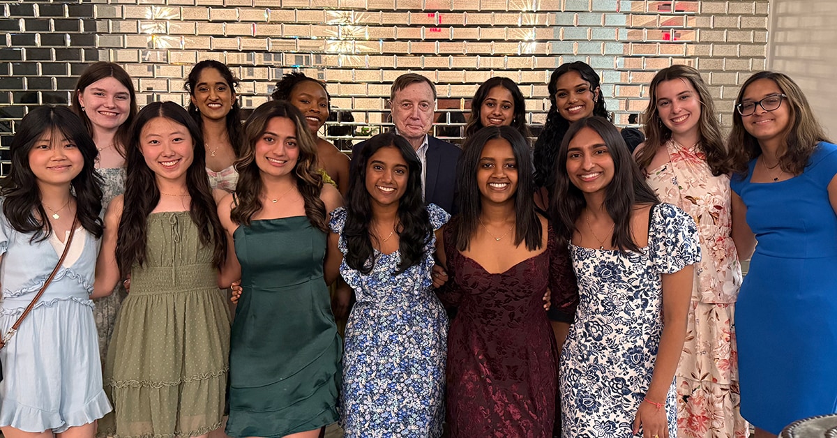 More EMSAP Students Pose With Dr. Pence In Front Of Silver Brick Wall