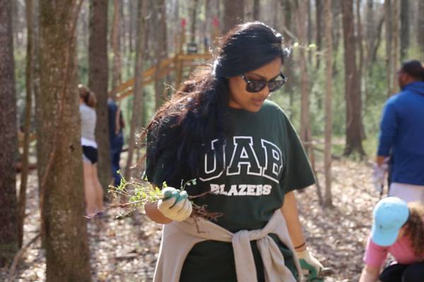 Group of students planting a tree.